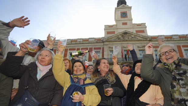 Varias personas festejan el aniversario del reloj en la Puerta del Sol. | ABC.ES