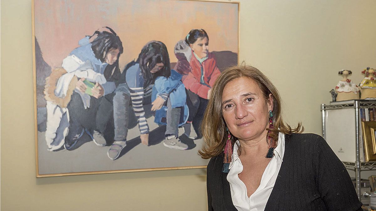 La artista Ana Prieto posa junto a uno de sus retratos infantiles en la galería de arte Bernesga. | VICENTE GARCÍA