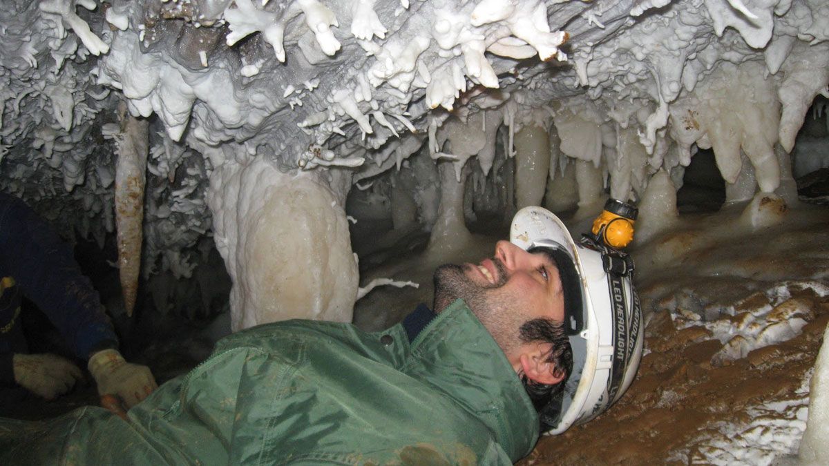 El ingeniero de Minas Manuel Cánovas, de la Asociación Aragonito Azul, observa las formaciones litogenéticas de la cueva Athenea, en Trabadelo. | A.A.