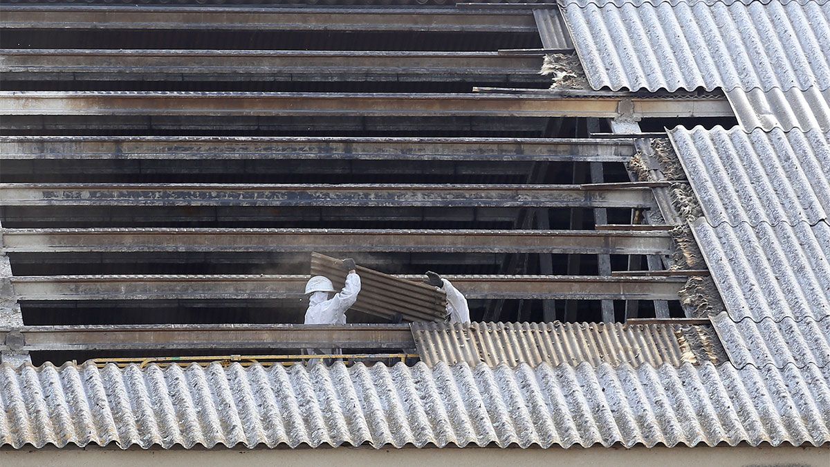 Dos trabajadores en tareas de desmontaje de una tejado de fibrocemento. | L.N.C.