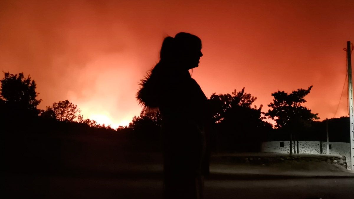 Una vecina de Boisán con el incendio del Teleno de fondo. | L.N.C.