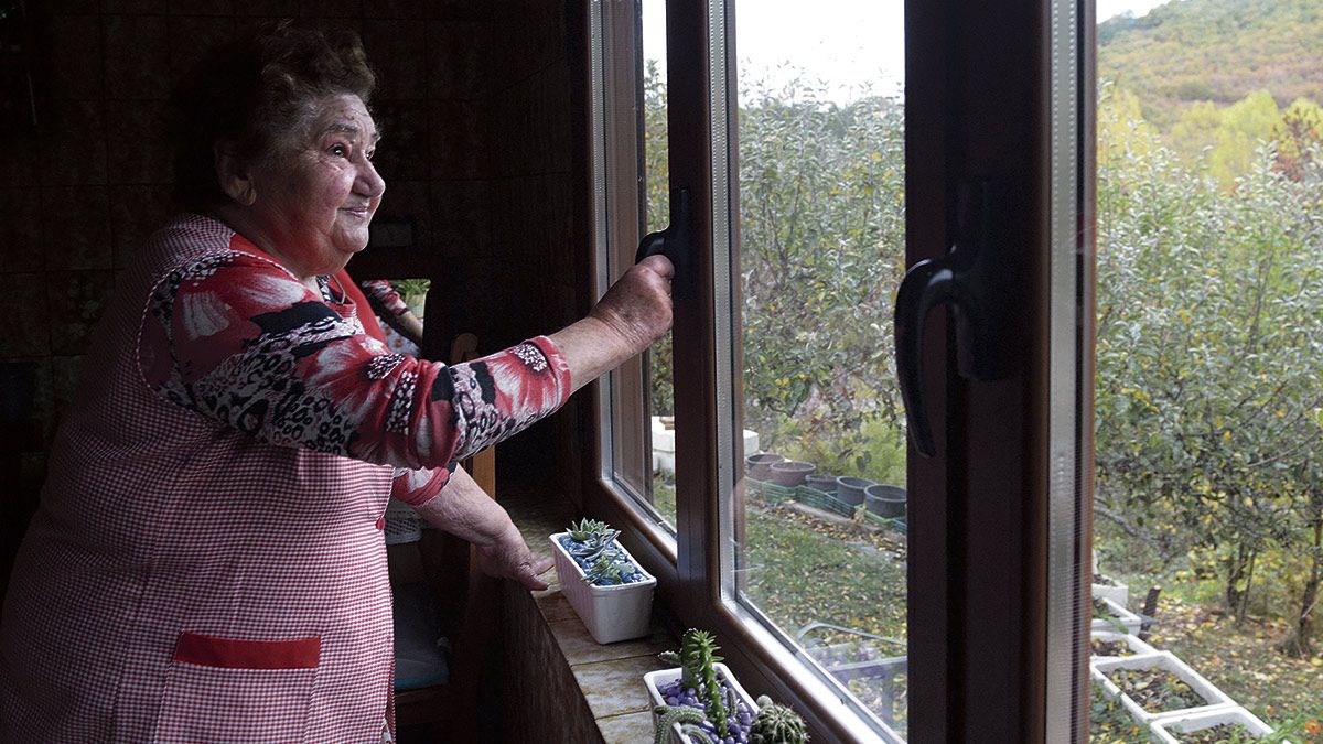 Isabel Fernández contempla por la ventana su viejo poblado de Casetas y va recordando cada una de las casas y negocios del pueblo. | MAURICIO PEÑA