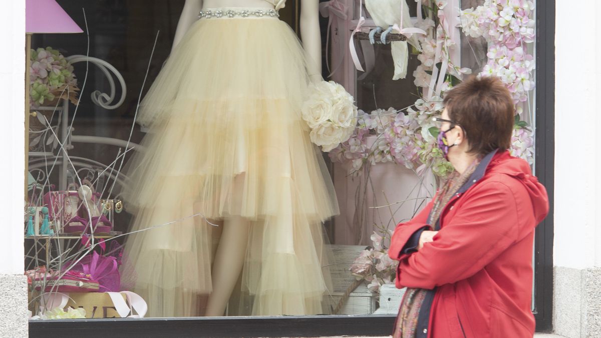 Una mujer mira un escaparate de un comercio en Ponferrada. | Ical