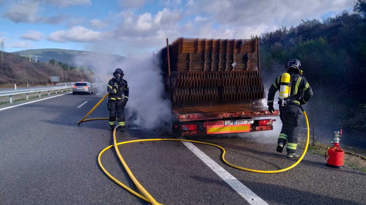 Los bomberos sofocando las llamas del camión que ardió en la A-6. | BOMBEROS DE PONFERRADA