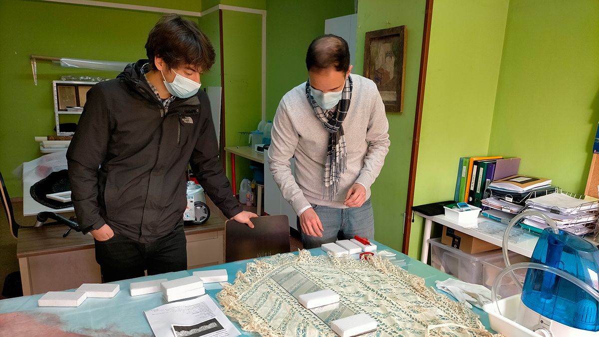El responsable del Mitle y restaurador textil, mostrando la recuperación de una pieza al diputado de Cultura, Pablo López Presa. | L.N.C.