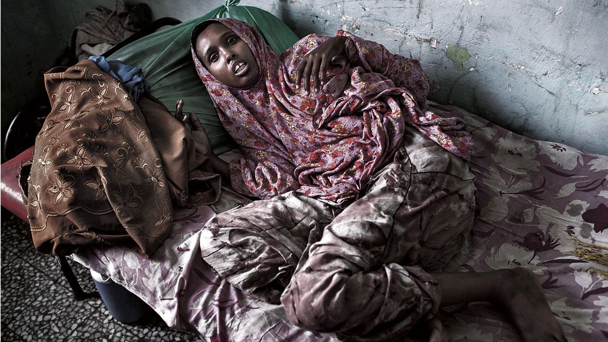 Huba, de 20 años, yace en una cama del hospital mental Doctor Hebab de Mogadiscio (Somalia). | JM LÓPEZ