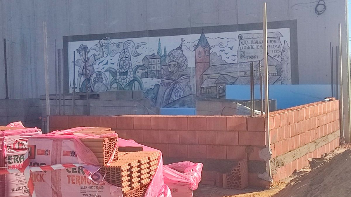 Obras para construir unos servicios en la zona aledaña del pabellón de Villacelama que taparán el mural que pintó Lolo en el fróntón de la localidad. | L.N.C.