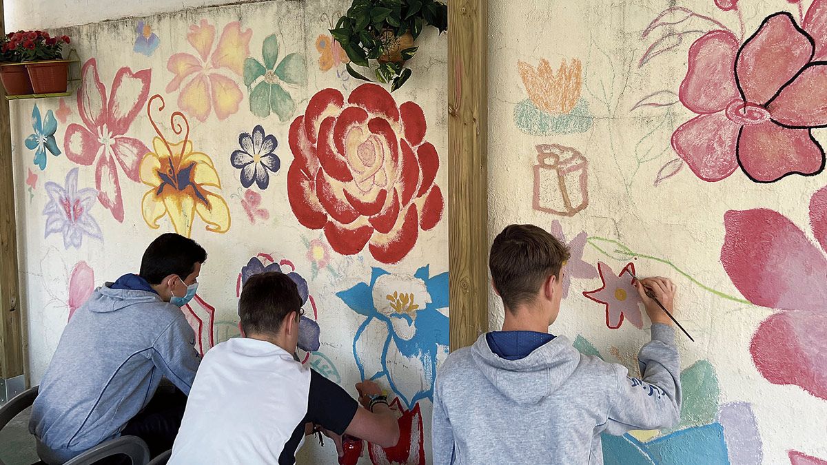 Tres de los alumnos participantes en la actividad colectiva pintando una de las paredes elegida. | MARISTAS