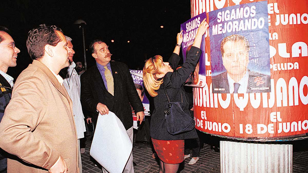 Amilivia y la fallecida IsabelCarrasco, pegando carteles. | MAURICIO PEÑA