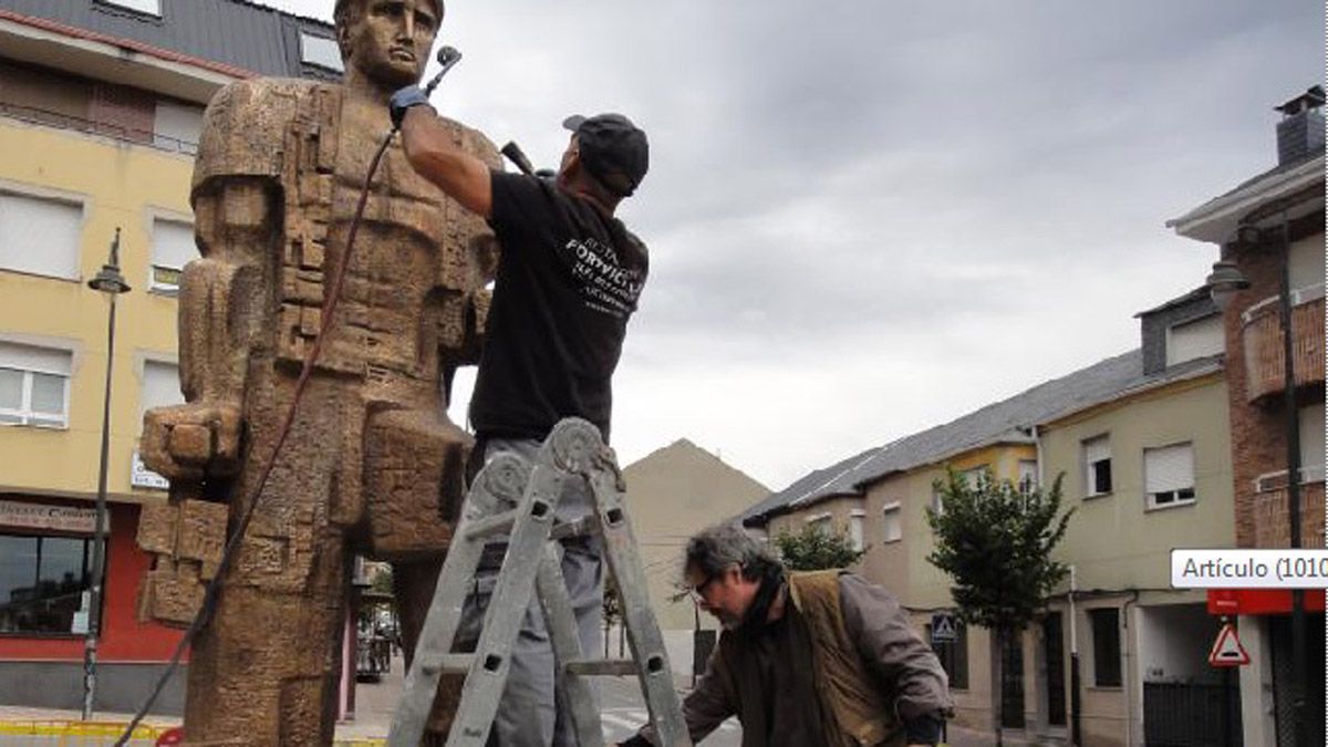 Tomás Bañuelos, abajo, durante la reparación de la escultura del minero. | D. M.