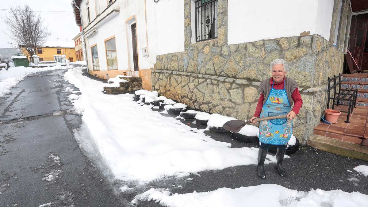 Una mujer retira la nieve de su puerta en Riello. | ICAL
