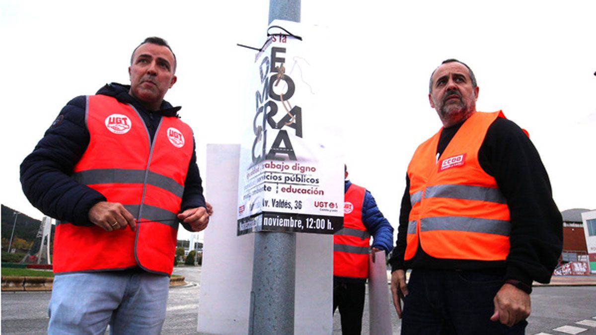 Los secretarios comarcales de UGT y CCOO durante la pega de carteles. | César Sánchez