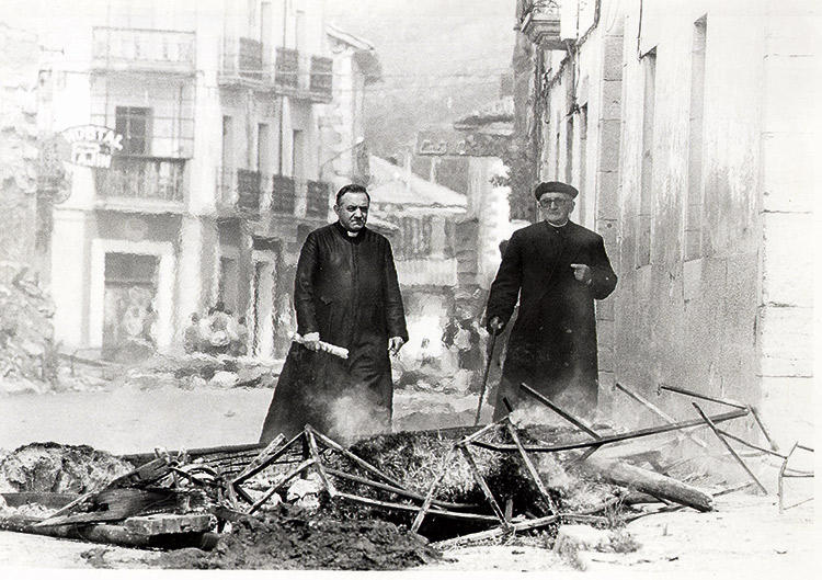 Don Antonio, cura de Riaño que fue quien entregó las llaves, y don Eustaquio, de Barniedo, atraviesan una barricada en aquellos días del fin del pueblo. | MAURICIO PEñA
