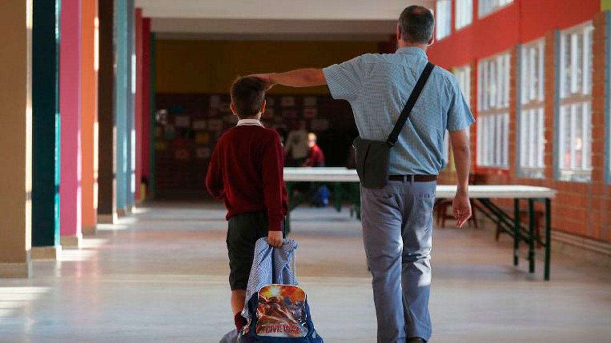 Un padre acompaña a su hijo en el primer día de clase después del verano. | ICAL
