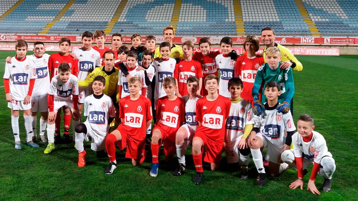 Foto de familia de los dos equipos y el equipo arbitral este martes en el Reino.