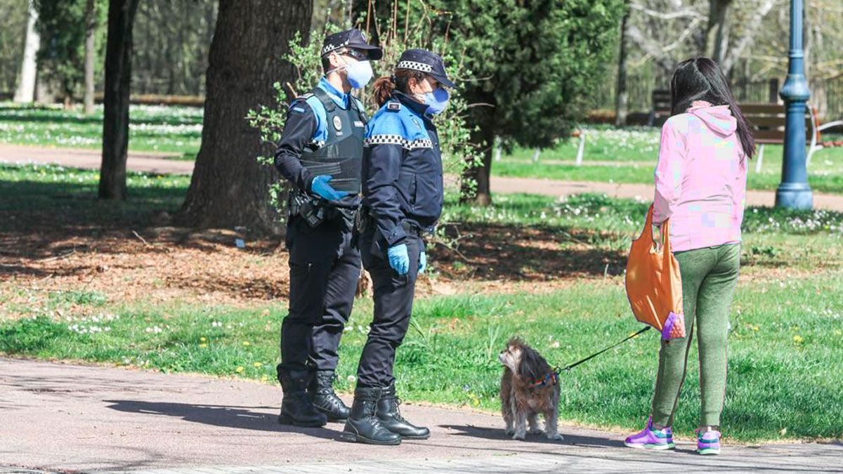 Agentes municipales advirtiendo de las restricciones a una viandante que había entrado en un parque. | P.M.