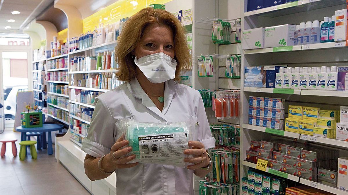 Una farmacéutica posa con una bolsa de mascarillas de tipo quirúrgico. | L.N.C.