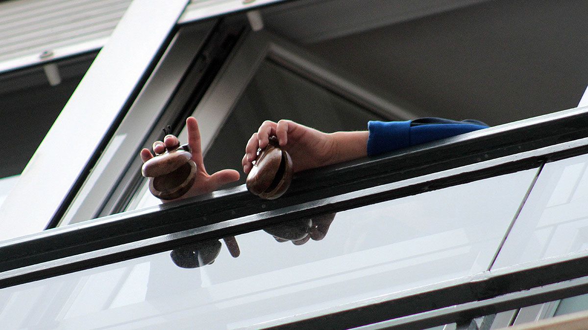 Imagen de un niño tocando las castañuelas en la ventana de su casa en León. | ICAL