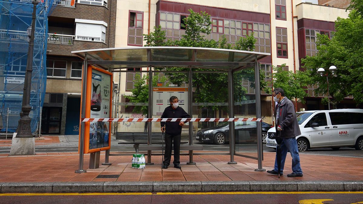 Un ciudadano se resguarda de la lluvia en una marquesina precintada en Ponferrada. | C.S (Ical)