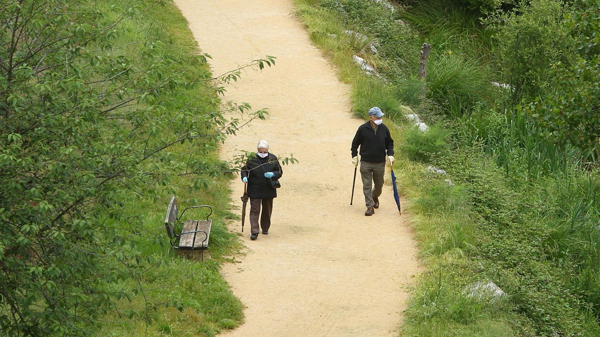 Dos personas mayores con mascarilla, por el paseo del río Sil de Ponferrada. | C.S. (Ical)