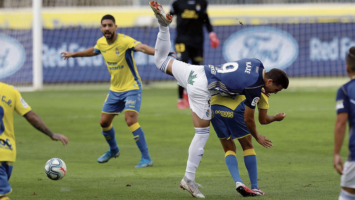Kaxe cae encima de un jugador de Las Palmas tras buscar un balón aéreo. | LALIGA
