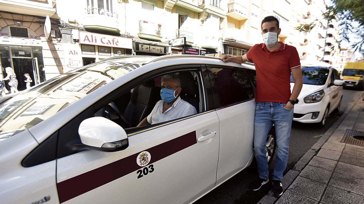 Los taxistas Juan Fernández y Héctor Morán esperan clientes en la parada de la Avenida Ramón y Cajal. | SAÚL ARÉN