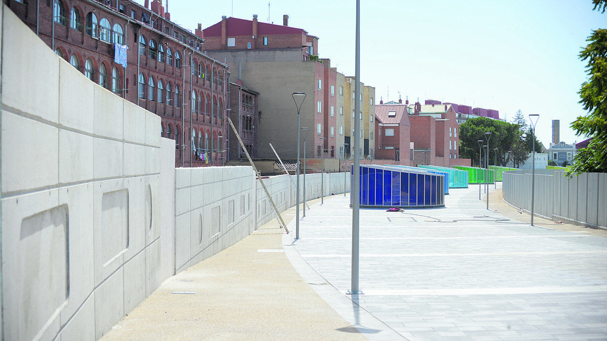 El muro entre la trasera de las casas de la calle Astorga y el Paseo del Ferrocarril evoca la imagen de los vagones de tren. | MAURICIO PEÑA El muro entre la trasera de las casas de la calle Astorga y el Paseo del Ferrocarril evoca la imagen de los vagones de tren. | MAURICIO PEÑA