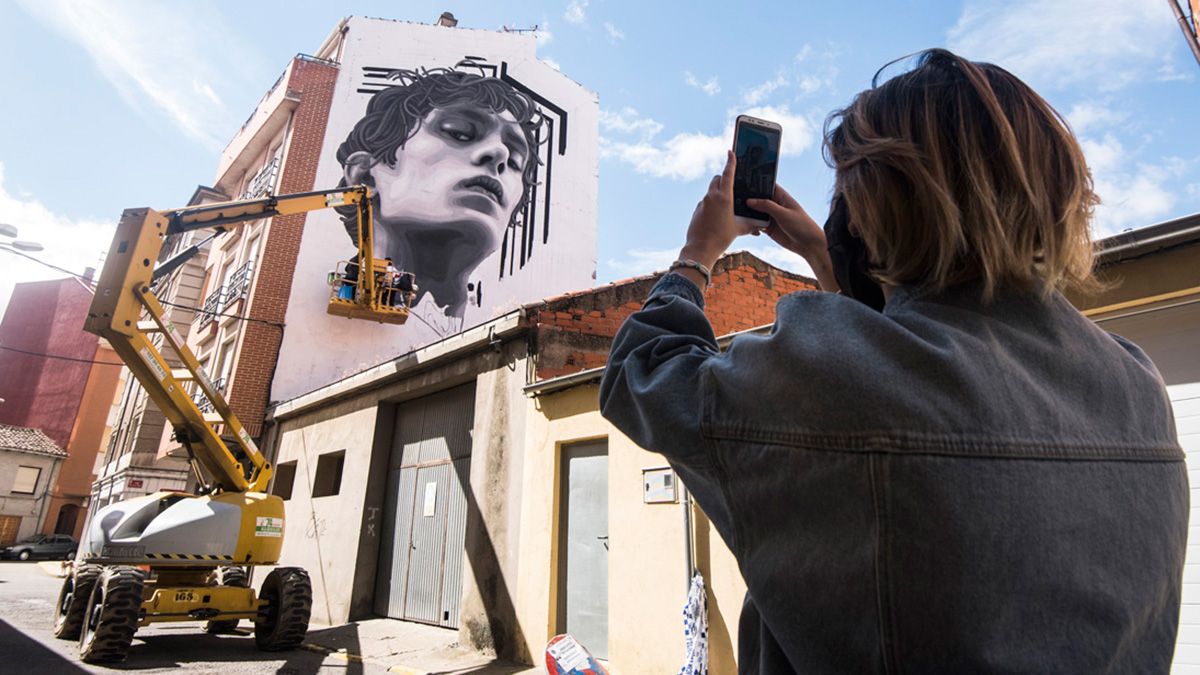 Los grafiteros llevan desde el jueves en La Bañeza a pleno rendimiento para seguir poniendo color a los muros del municipio. | SAÚL ARÉN