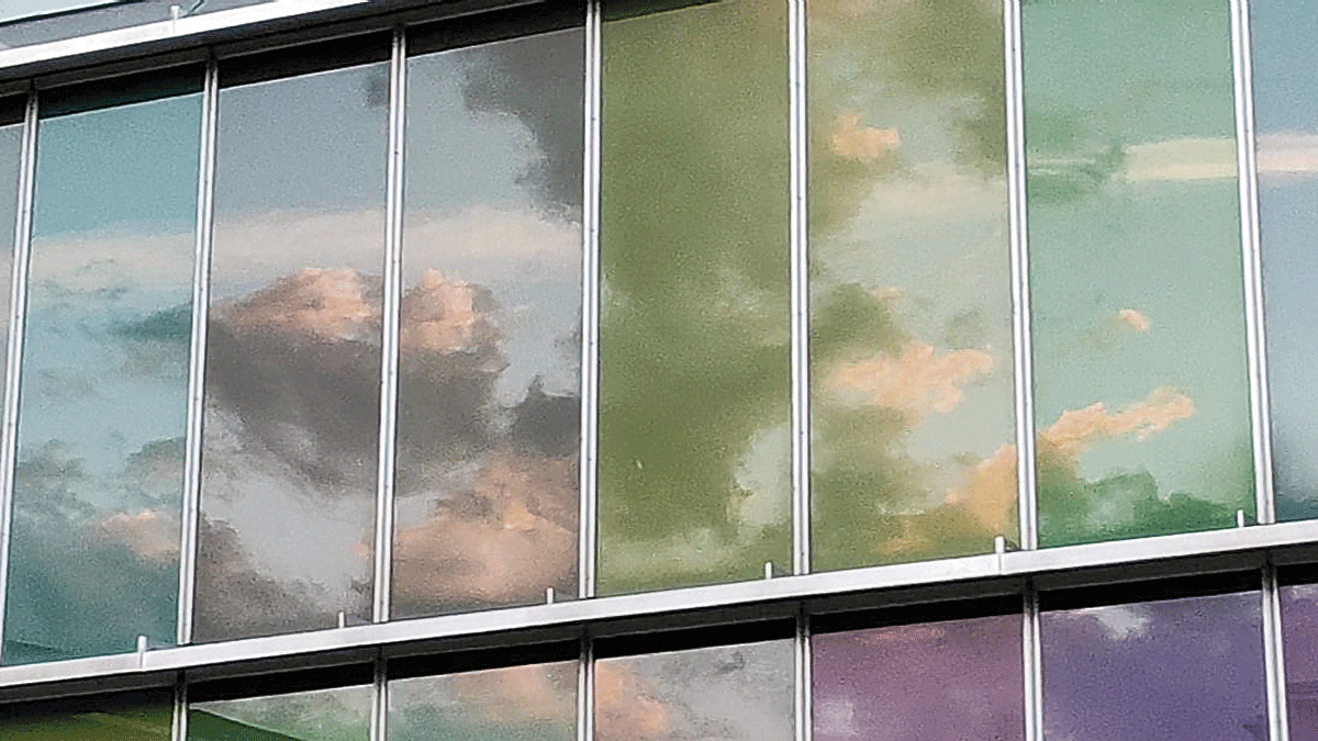 Las nubes se reflejan en los paredes acristaladas del Musac.