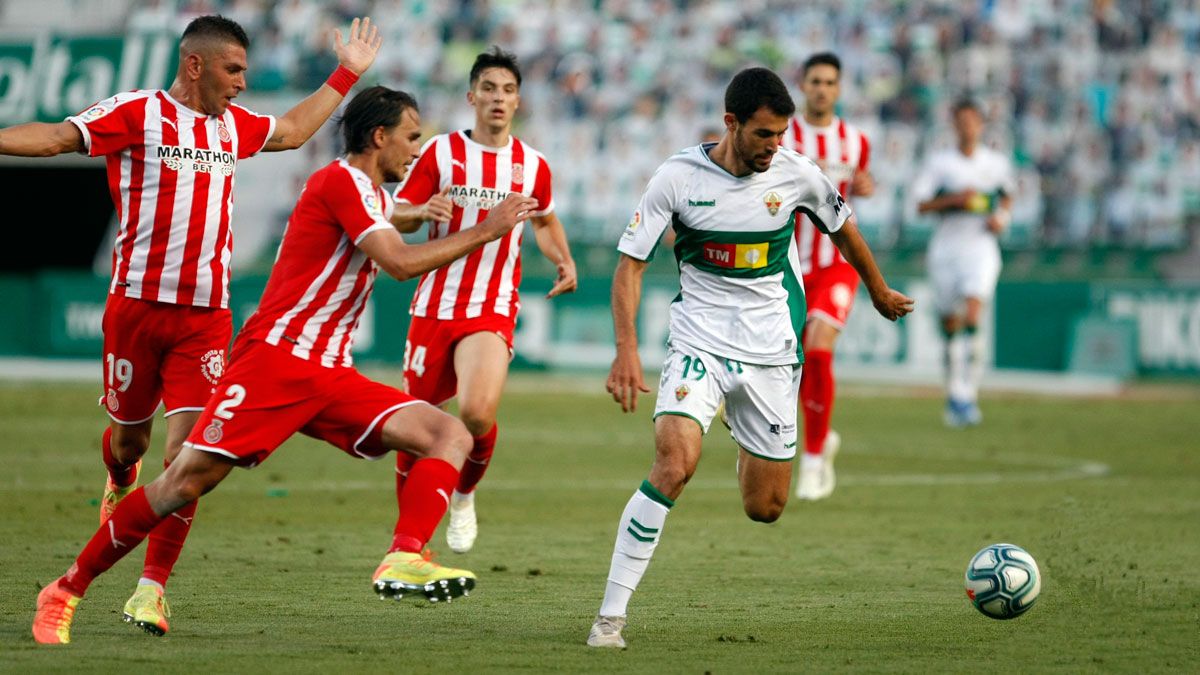 Claudio conduce el balón durante un partido con el Elche ante el Girona. | LA LIGA