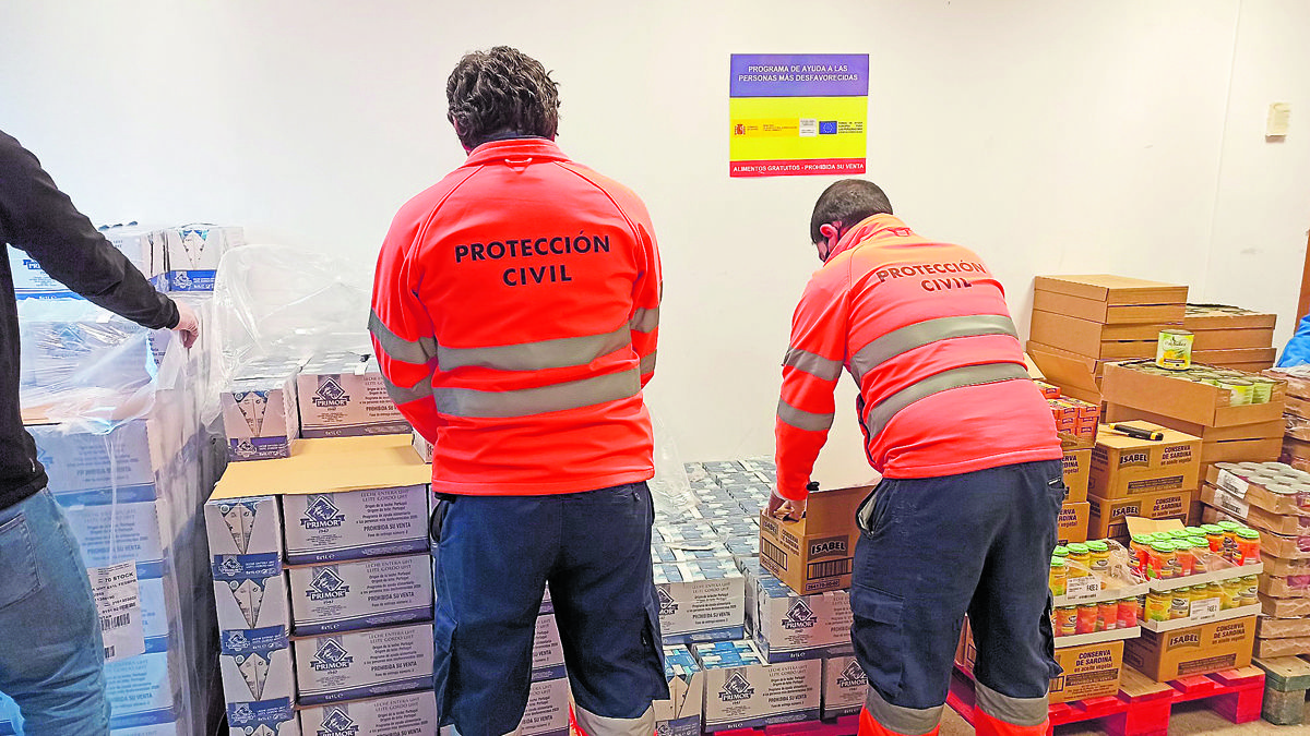 Voluntarios de Protección Civil colaboran en el reparto de alimentos. | L.N.C. Voluntarios de Protección Civil colaboran en el reparto de alimentos. | L.N.C.