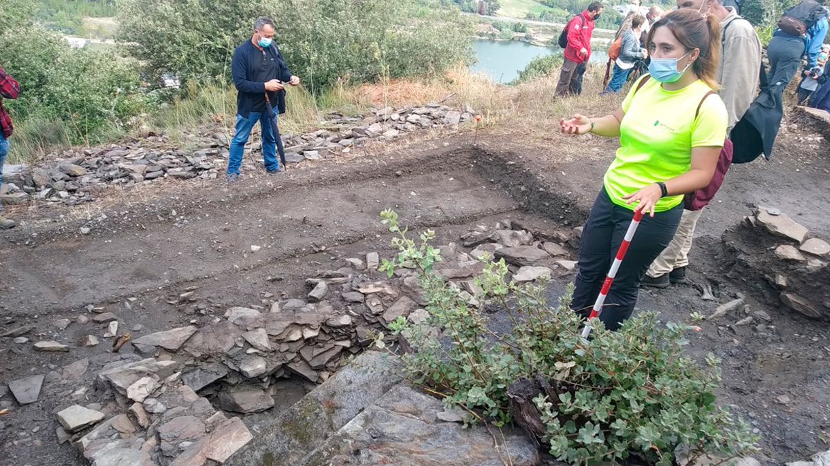 Celtia Rodríguez en una visita guiada, explicando la aparición del nuevo muro,  en la que participó el alcalde de Vilamartín, al fondo de la imagen. | M.I.