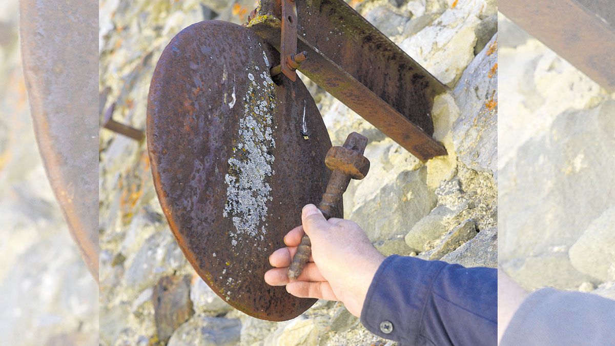 La singular ‘campana’ de la iglesia de Piornedo, el tope y una rueda del tren. | MAURICIO PEÑA