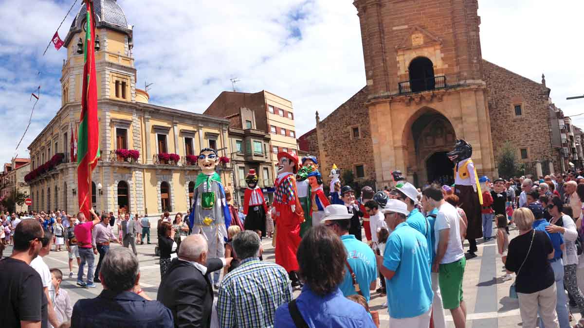 Vista de la Plaza Mayor de La Bañeza, al mediodía de ayer tras la misa en honor de la Patrona, con el pendón y los gigantes y cabezudos desfilando. | ABAJO