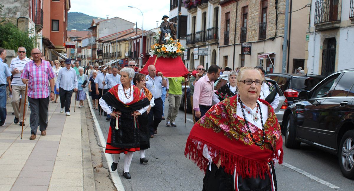 Las mujeres van ataviadas con los trajes regionales típicos de la zona, al fondo los hombres del pueblo llevan a hombros a San Roque. | Alfredo Hurtado