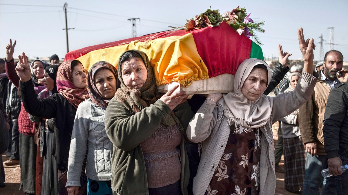 Familiares de una miliciana kurda perteneciente a las Unidades de Protección Popular (YPG) llevan el ataúd con su cuerpo hacia el cementerio de Kobane en Siria. | JM LÓPEZ