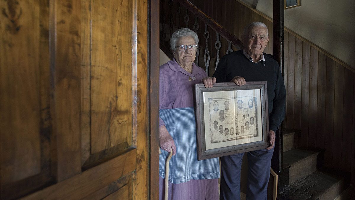 Aurora y Vicente, 64 años casados, sujetan en sus manos una orla en la que aparecen ellos, sus padres y los ocho hijos que han criado. |  MAURICIO PEÑA