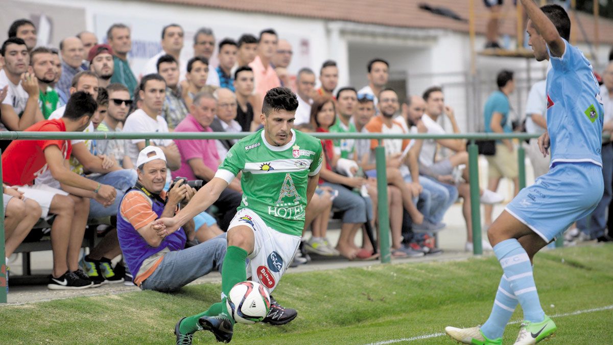 Manu Martínez controla el balón mientras el jugador del Coruxo pide que se ha ido por la banda. | MAURICIO PEÑA
