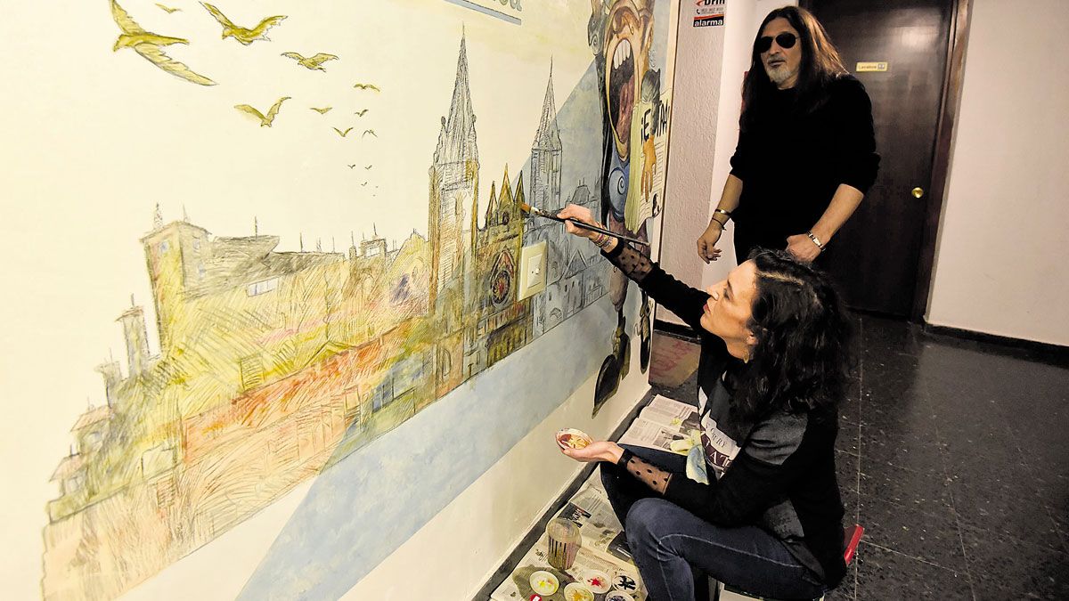 Moñi currando al pincel en uno de los numerosos murales que ha realizado con Lolo; en este caso a la puerta de La Nueva Crónica de León. | SAÚL ARÉN