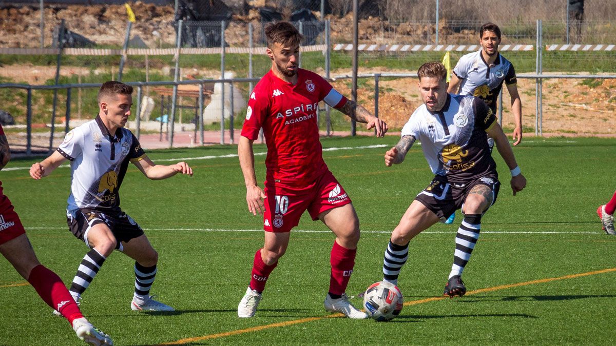 Sergio Marcos protege el balón ante dos jugadores de Unionistas durante el partido de ida. | UNIONISTAS