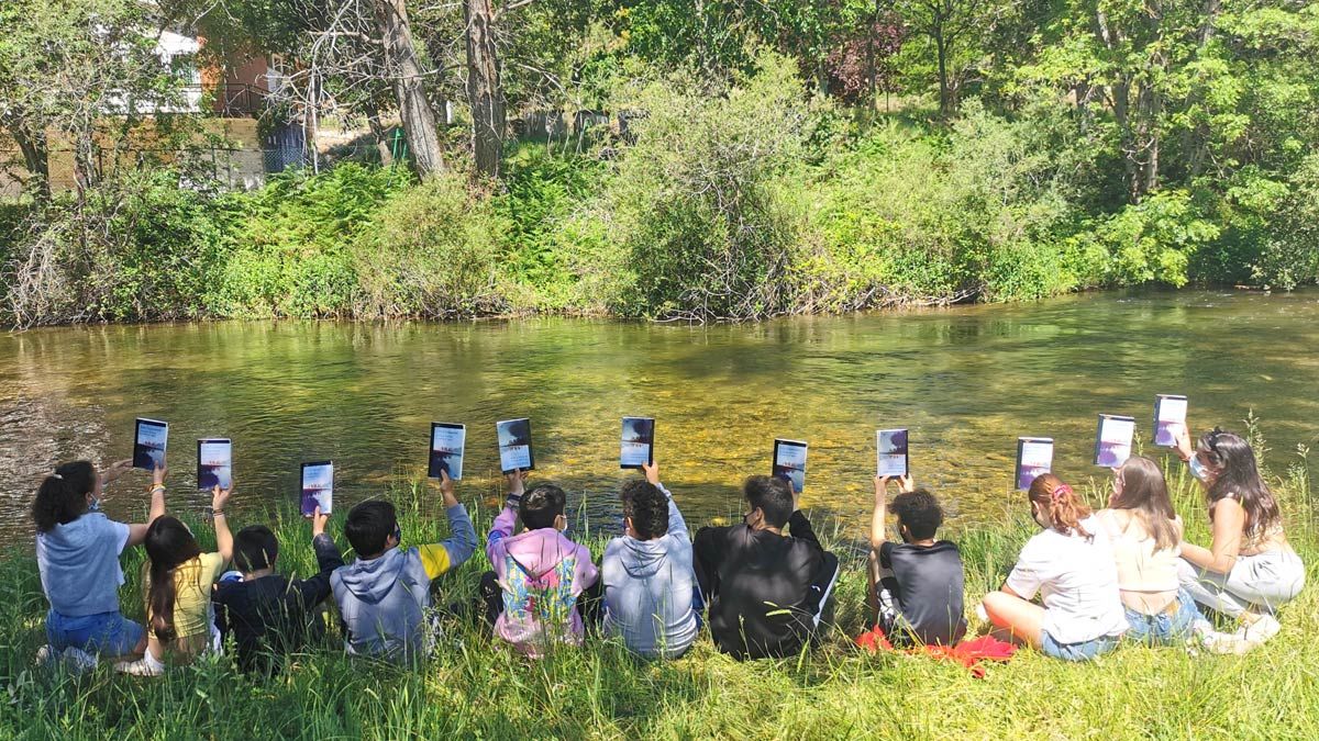 Los alumnos del instituto de Boñar leyendo la obra de Julio Llamazares ‘Distintas formas de mirar el agua’ junto al río Porma. Los alumnos del instituto de Boñar leyendo la obra de Julio Llamazares ‘Distintas formas de mirar el agua’ junto al río Porma.