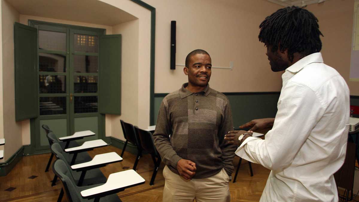 Un joven camerunés conversa con el director nacional del Servicio Jesuíta al Refugiado en Sudáfrica, Rampe Hlobo sj, en una imagen de archivo. | ICAL