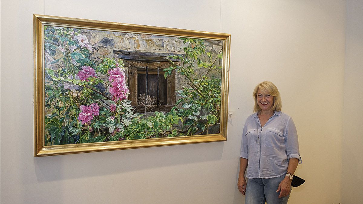 La artista palentina Marián López posa ante su cuadro de una ventana en la galería Sharon Art. | VICENTE GARCÍA