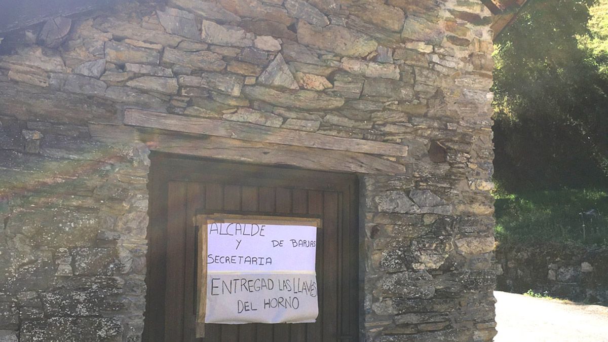 Exterior del edificio del horno tradicional, donde han colgado un cartel.