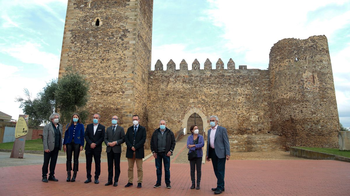 Al fondo el castillo de Laguna de Negrillos y en un primer plano las autoridades en la visita de este miércoles a la fortaleza. | ICAL