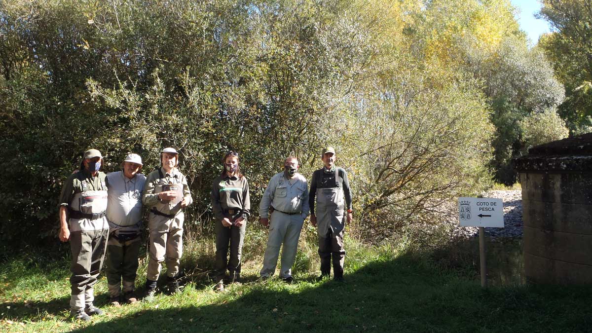 Pescadores posan junto a un cartel indicador de un coto de pesca | R.P.N.