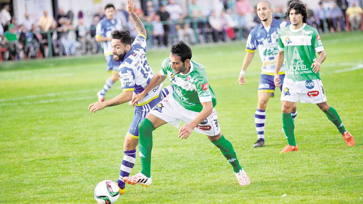 Roberto Puente pelea un balón ante la mirada de Víctor Andrés durante el choque frente a la Arandina. | DANIEL MARTIN