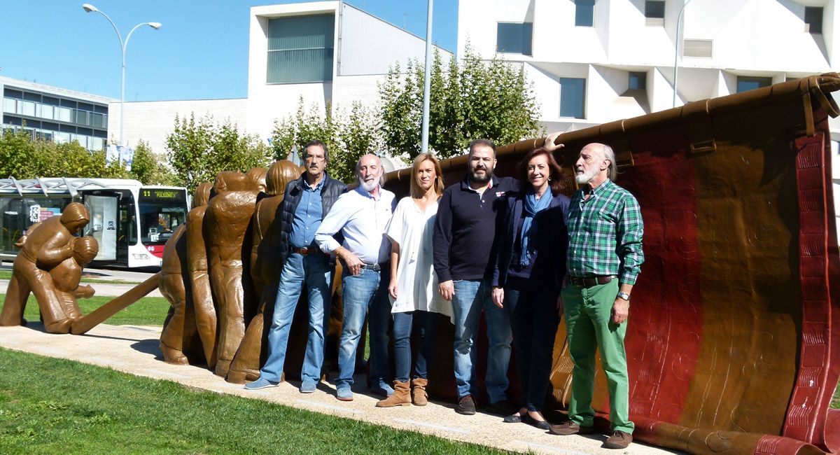 Los componentes de La Rueca posan junto a la nueva escultura que homenajea a los pendones leoneses.