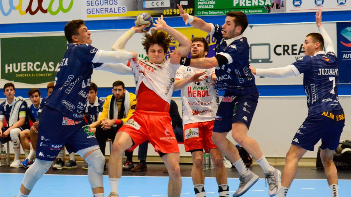 Santista y Liapis agarran al atacante durante el partido de Copa del miércoles en Nava. | AMADOR MARUGÁN