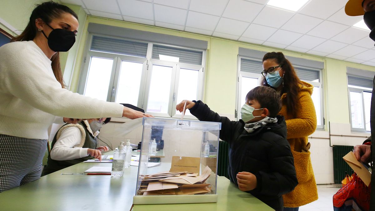 Un niño acompaña a votar a su familia e introduce uno de los votos en una urna en Ponferrada. | Ical